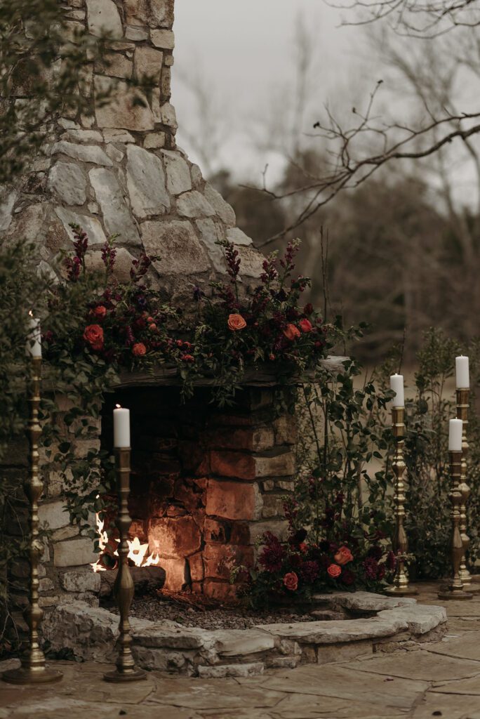Stone fireplace with candles and floral arrangements