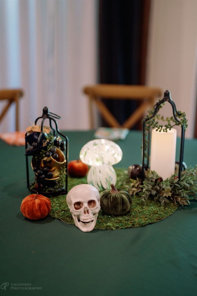 Halloween-themed table decor with skull, pumpkins, and candle