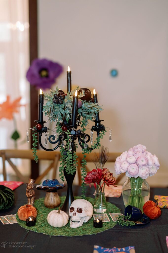 Halloween wedding centerpiece with black candles, skull, and florals