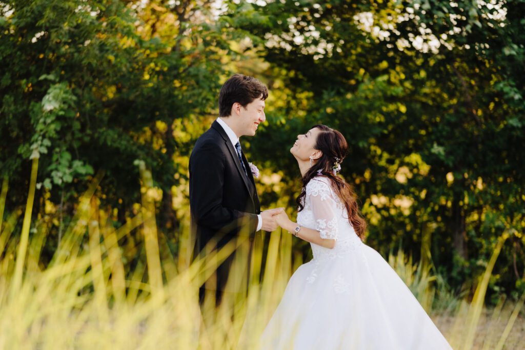 Bride and groom holding hands in garden setting