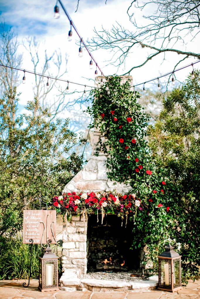 Outdoor fireplace with floral decor and string lights