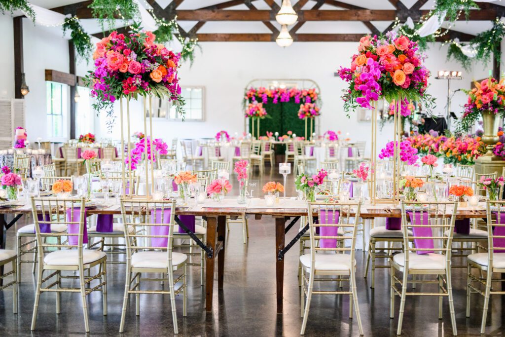 Elegant reception setup with colorful floral centerpieces and gold chairs