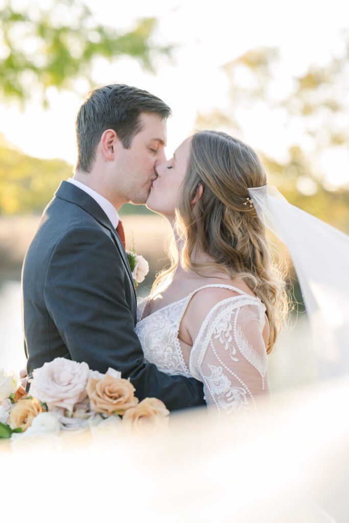Bride and groom kissing at sunset