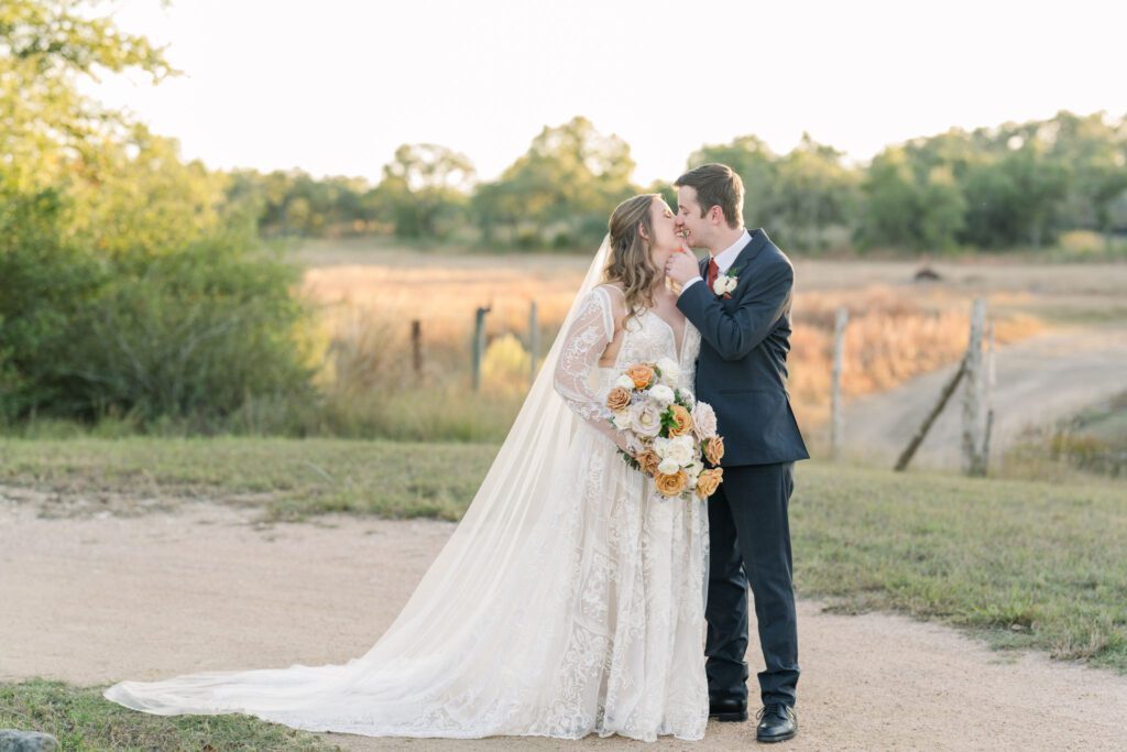 Bride and groom kissing on a country path