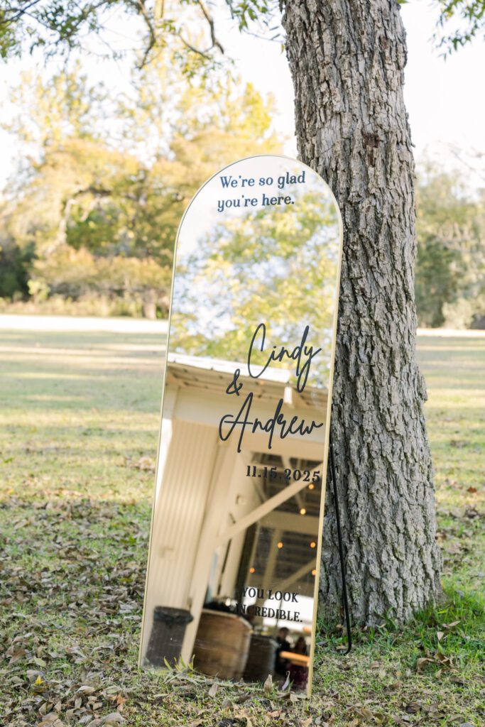 Wedding welcome mirror beside a tree