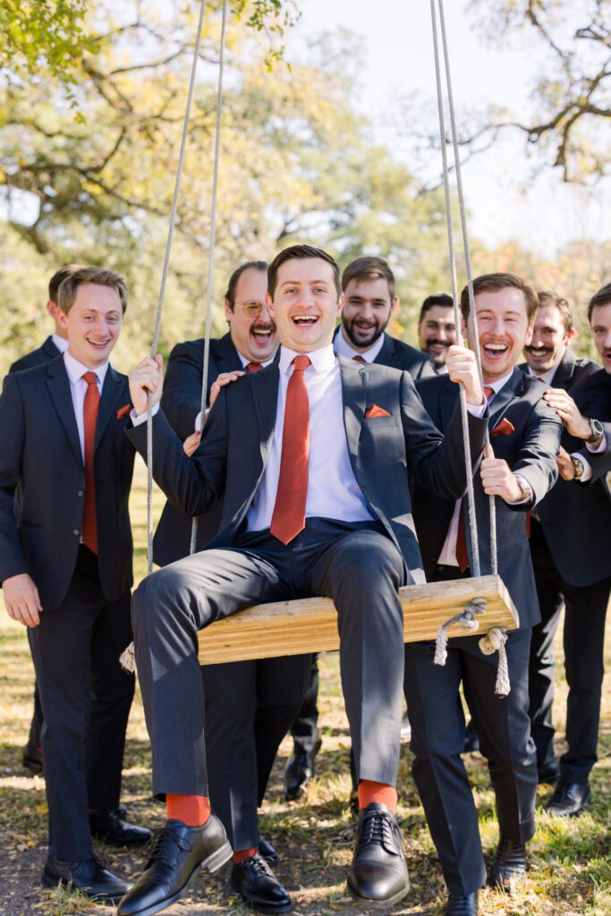 Groom sitting on a wooden swing
