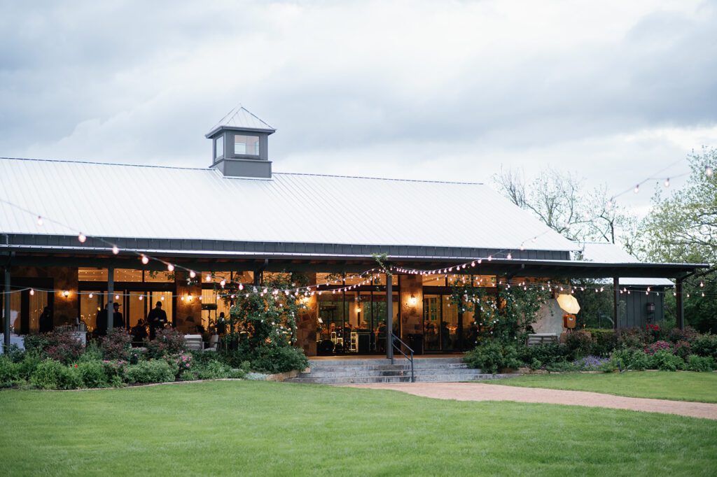 Pecan Springs Ranch venue exterior with string lights and lawn