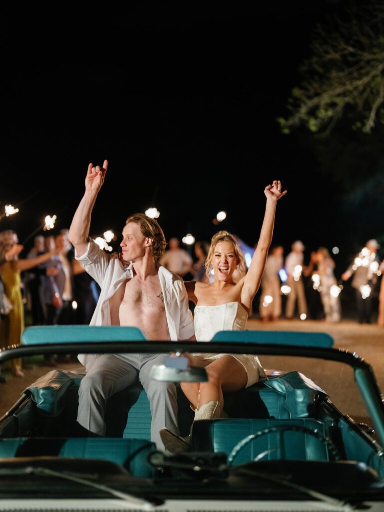 Newlyweds celebrating in vintage convertible