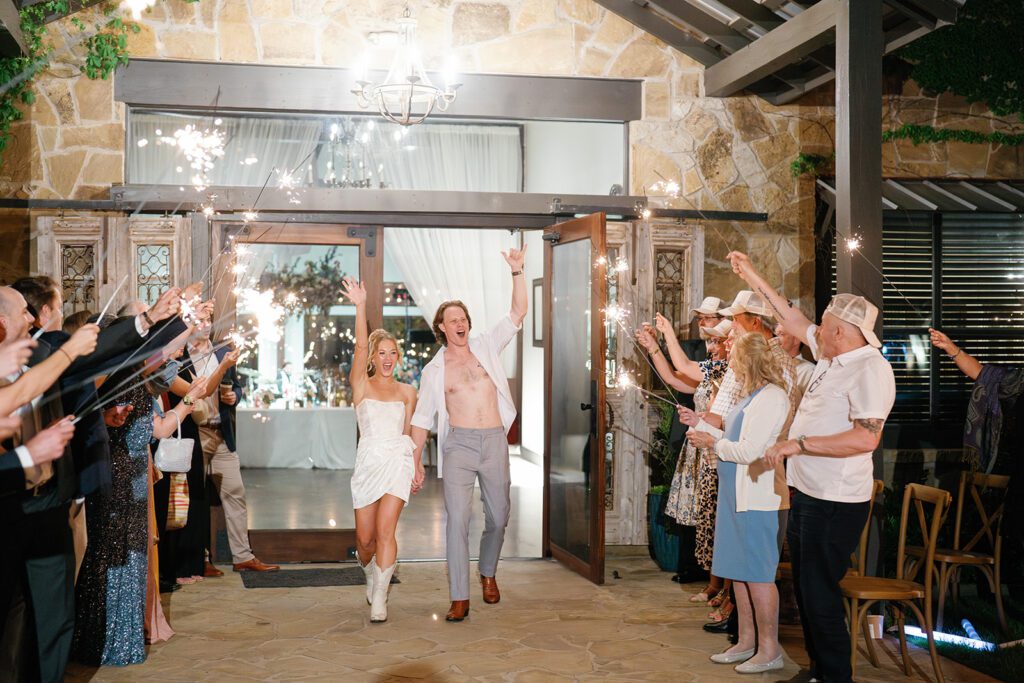 Newlyweds walking through sparkler exit at Pecan Springs Ranch