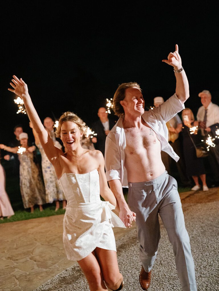 Newlyweds celebrating during sparkler exit at Pecan Springs Ranch