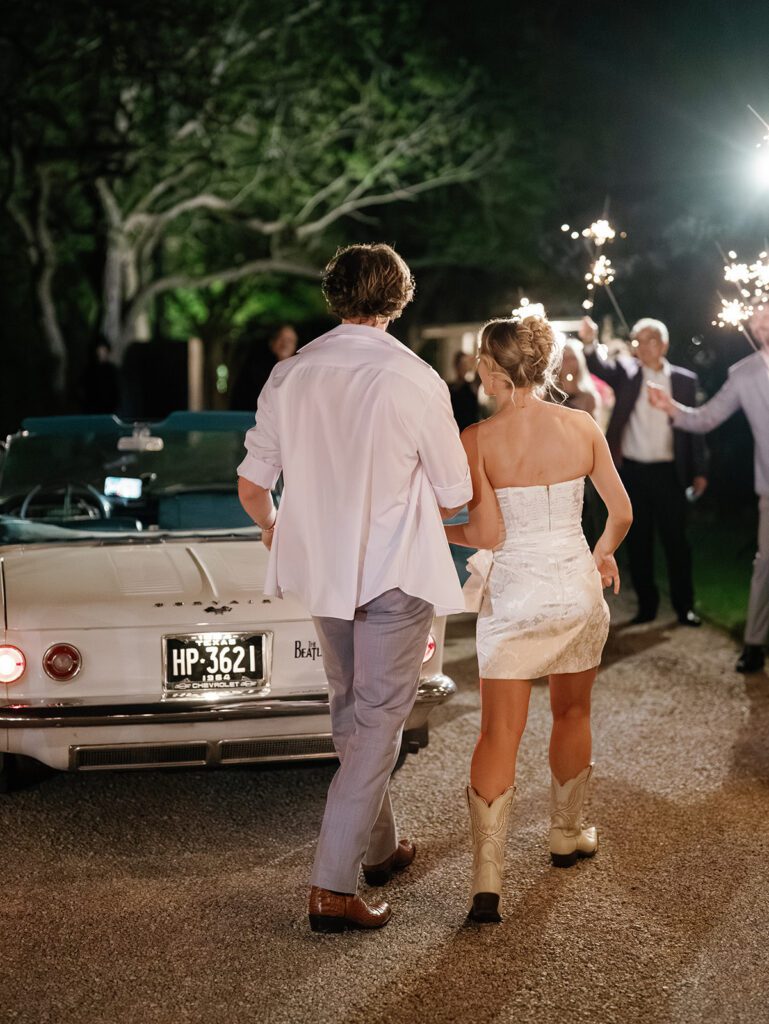 Newlyweds walking toward vintage convertible